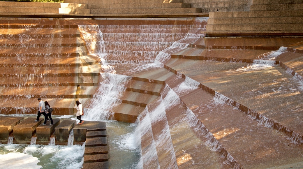 Fort Worth Water Gardens que incluye una fuente y también un grupo pequeño de personas