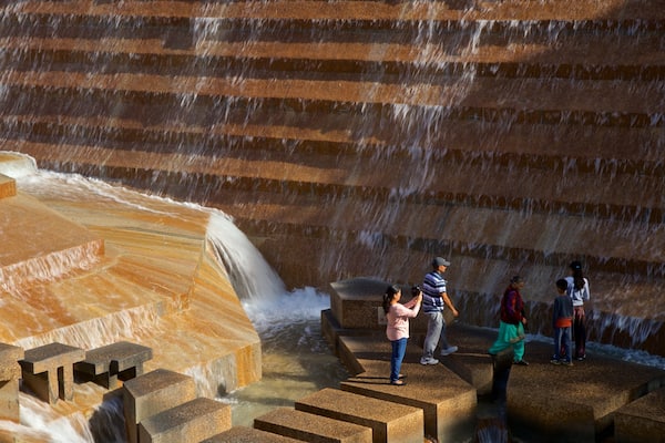Fort Worth Water Gardens mostrando una fuente y también un pequeño grupo de personas