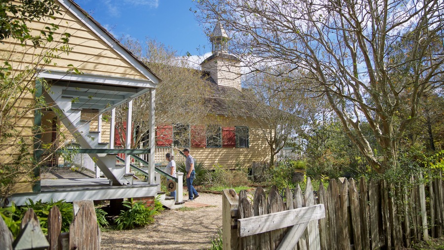 Vermilionville which includes a garden and a house as well as a couple