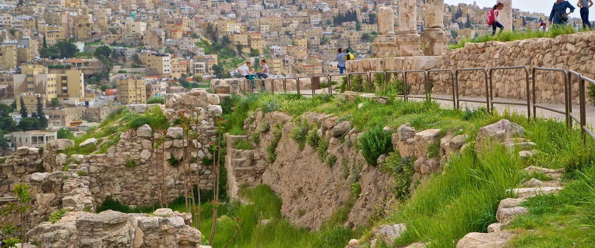 Ciudadela de Amán que incluye vistas de paisajes y una ciudad y también un pequeño grupo de personas