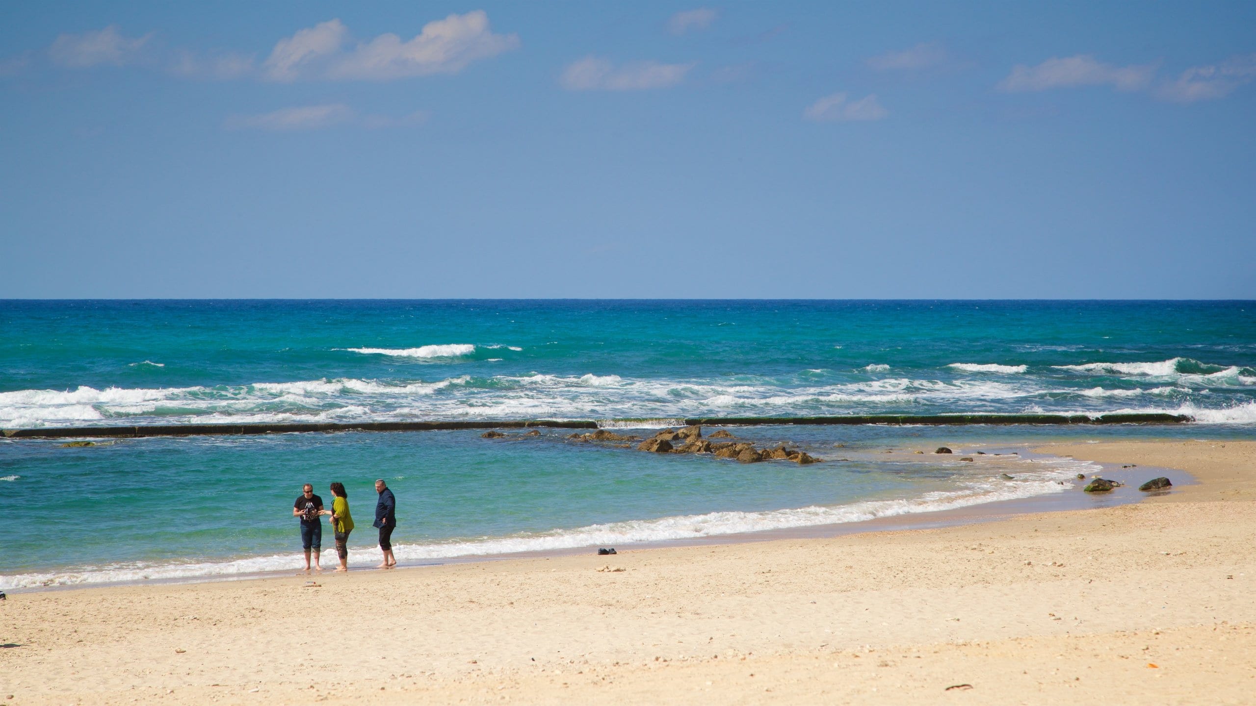 St Maarten and St Martin which includes general coastal views and a beach as well as a small group of people