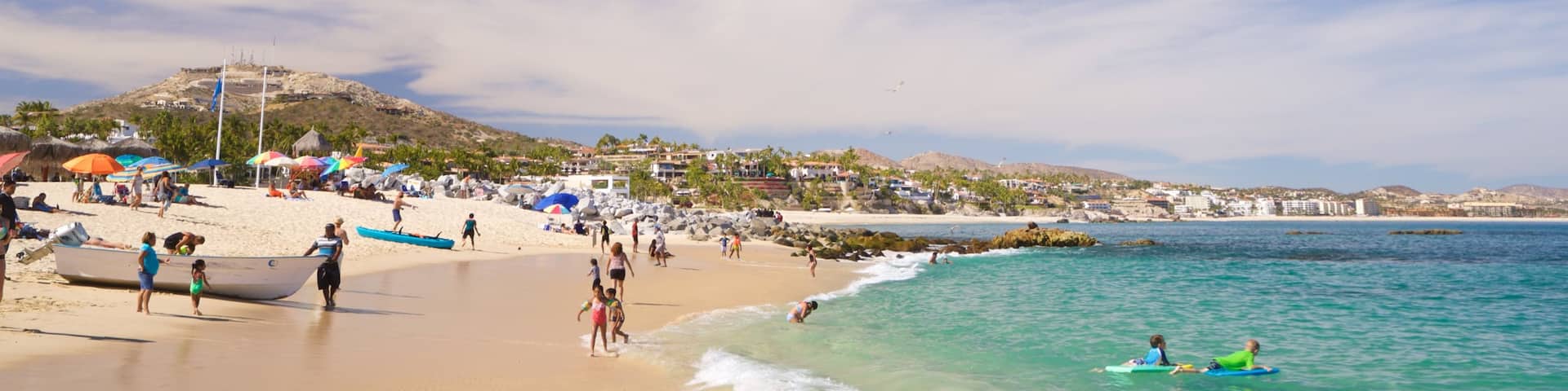 Palmilla Beach which includes general coastal views and a beach as well as a small group of people