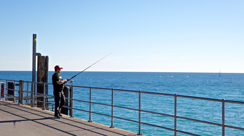 Glenelg Jetty featuring general coastal views and fishing as well as an individual male