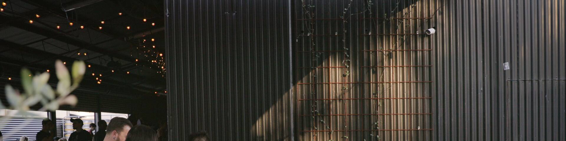 All Inn Brewing Co. featuring outdoor eating as well as a small group of people