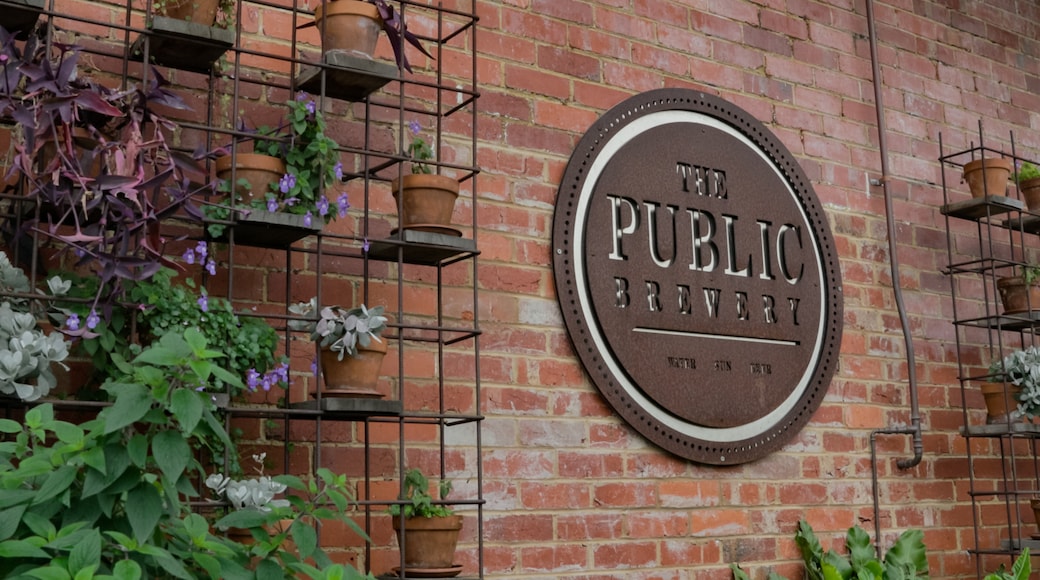 The Public Brewery featuring signage and flowers