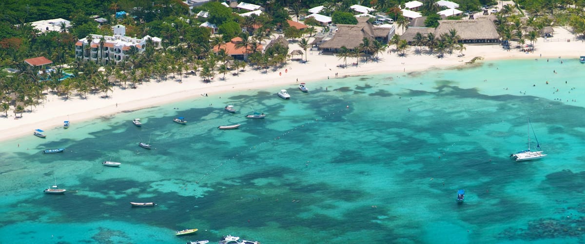 Riviera Maya que incluye una playa, escenas tropicales y una ciudad costera