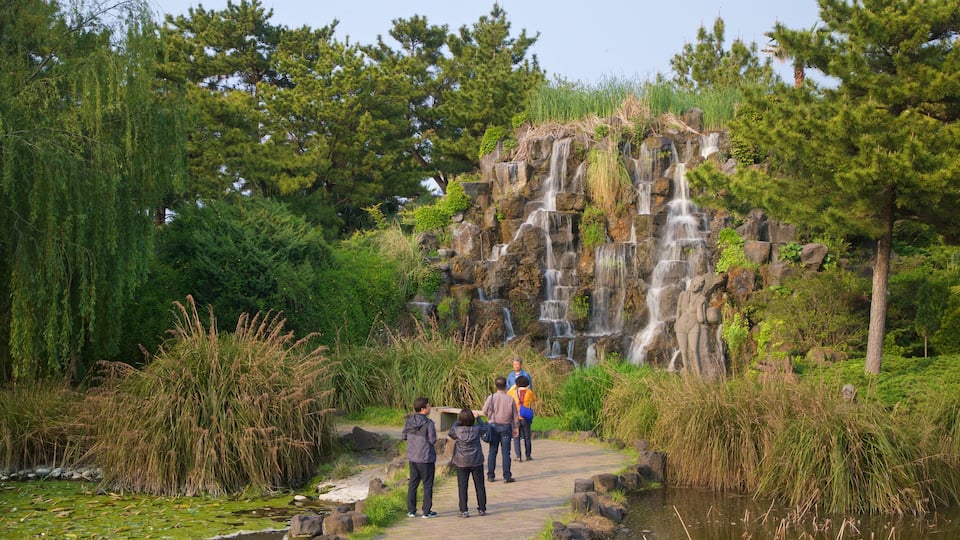 Hallim featuring a garden and a cascade as well as a small group of people