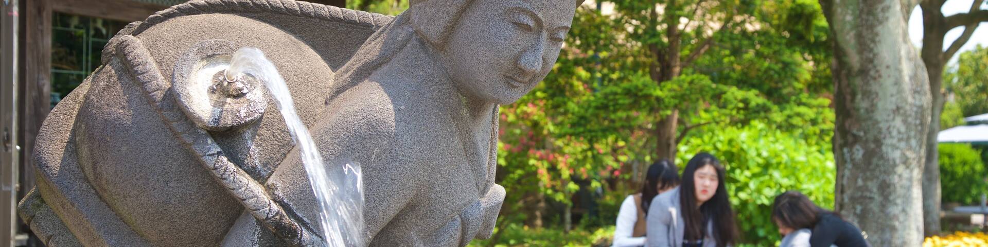 Jeju Folk Village Museum showing a statue or sculpture and a fountain