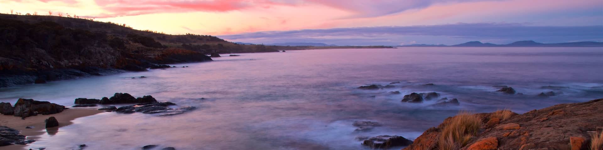 Swansea which includes rugged coastline, general coastal views and a sunset