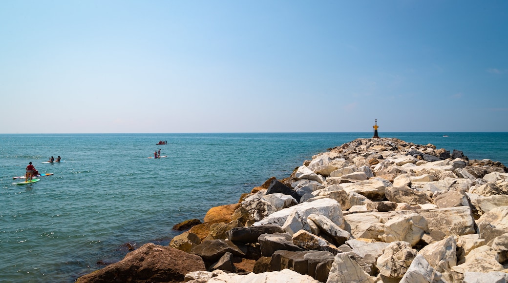 Cabopino Beach which includes kayaking or canoeing and general coastal views as well as a small group of people