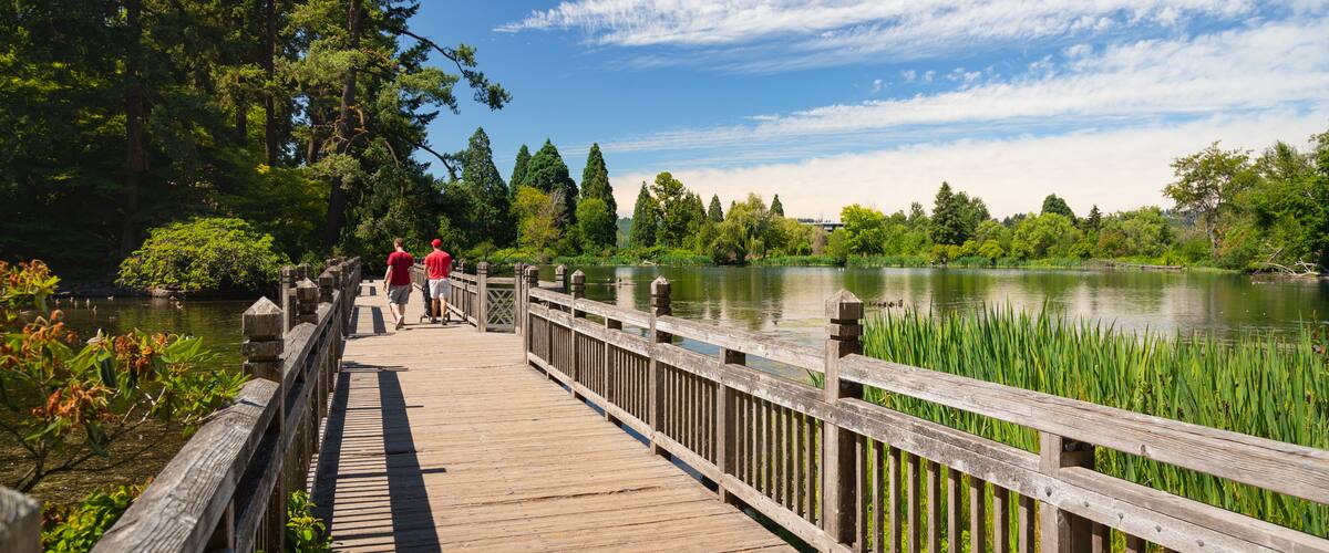 Crystal Springs Rhododendron Garden showing a bridge and a lake or waterhole as well as a couple