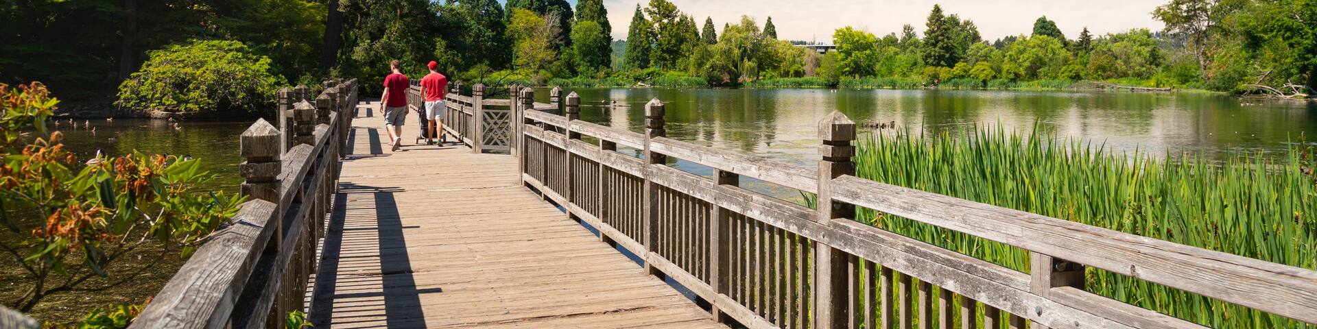 Crystal Springs Rhododendron Garden showing a bridge and a lake or waterhole as well as a couple