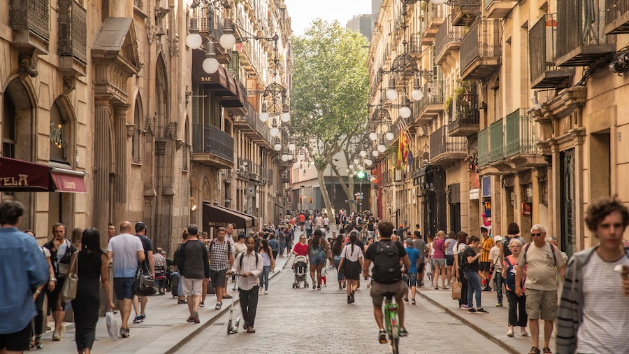 Crowded street view in the Gothic Quarter of Barcelona, featuring historic architecture.