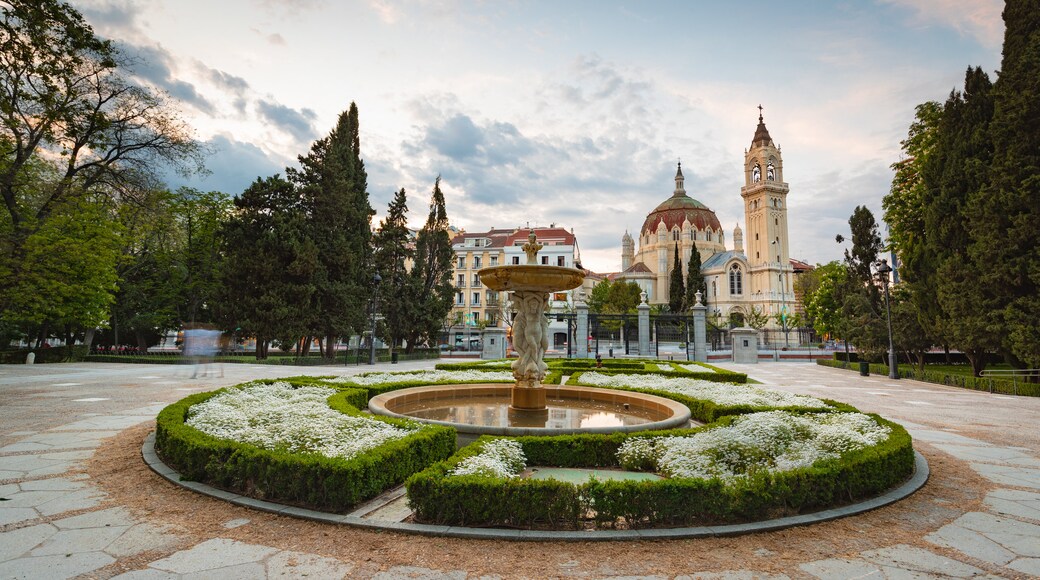 Church of San Manuel y San Benito showing flowers, a fountain and a sunset