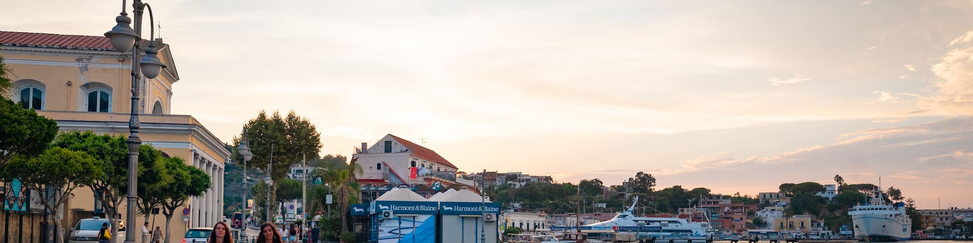 Ischia Port featuring a bay or harbor and a sunset as well as a couple