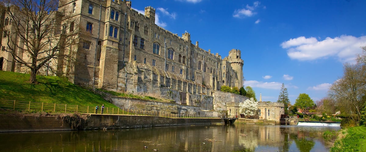 Warwick Castle featuring château or palace, a river or creek and heritage architecture