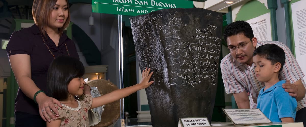 Museo Islámico de Penang mostrando vistas de interior y señalización y también una familia