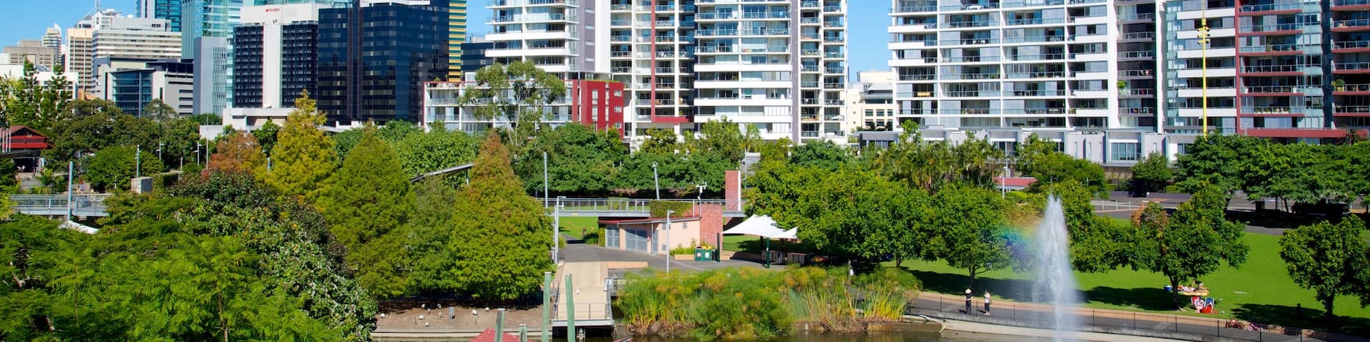 Roma Street Parkland featuring a fountain, a skyscraper and a pond