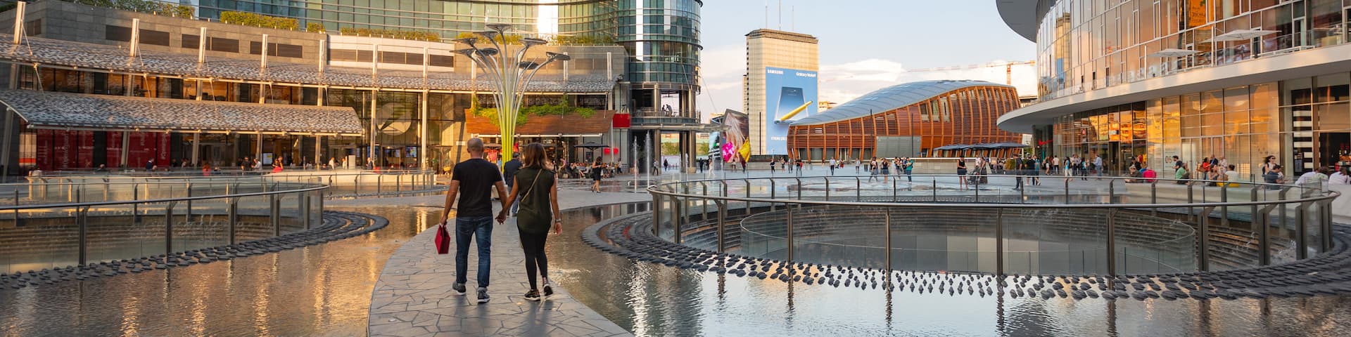 Piazza Gae Aulenti showing street scenes and a fountain as well as a couple