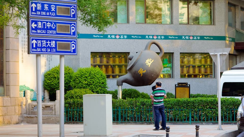 Wangfujing Street showing signage and outdoor art as well as an individual male