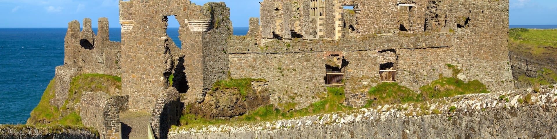 Dunluce Castle which includes heritage elements and a ruin as well as a small group of people