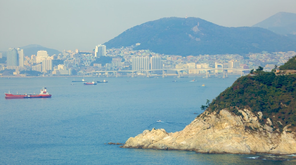 Taejongdae Park which includes rocky coastline, a coastal town and a bay or harbour