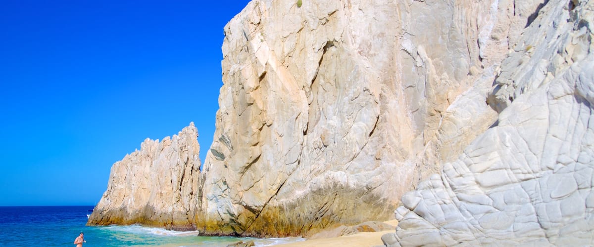 Playa de los Enamorados que incluye una playa de arena y costa escarpada