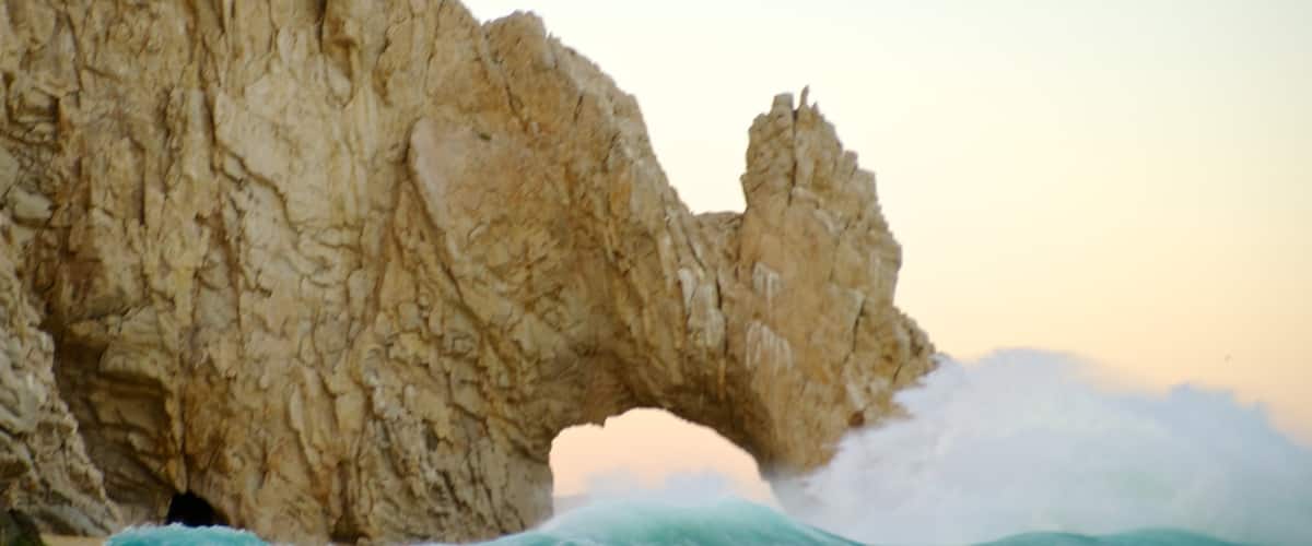 The Arch featuring waves and rocky coastline