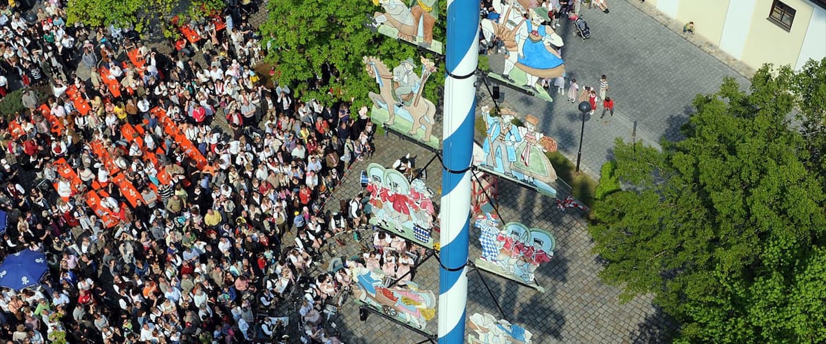 Ismaning which includes a square or plaza and a small town or village as well as a large group of people
