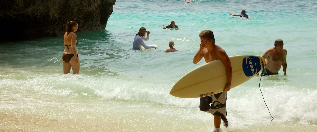 Plage d\'Uluwatu montrant baignade, surf et plage