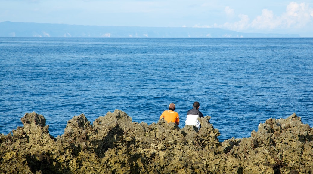 Nusa Dua Beach showing rugged coastline as well as a small group of people