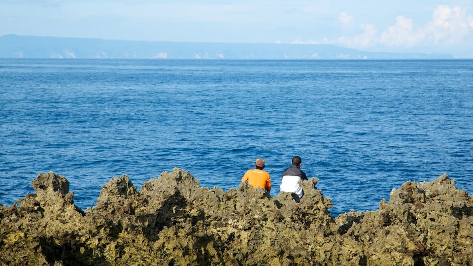 Nusa Dua Beach which includes rocky coastline as well as a small group of people