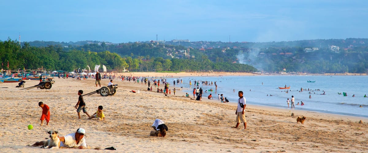 Jimbaran Beach which includes a beach as well as a large group of people
