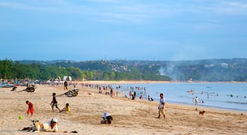 Jimbaran Beach showing a beach as well as a large group of people