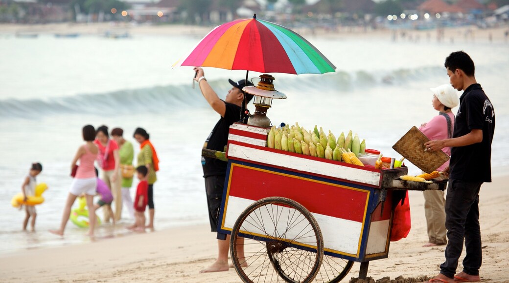 Jimbaran Beach showing a beach as well as a small group of people