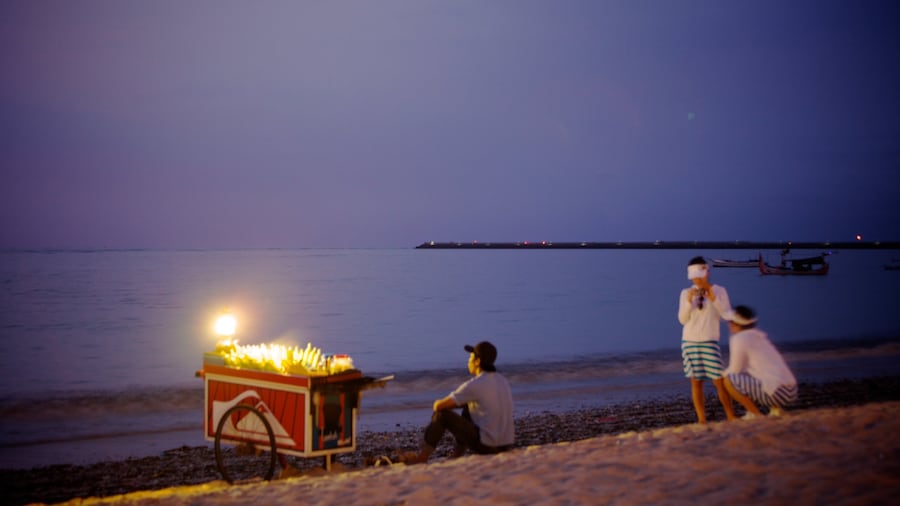 Jimbaran Strand som viser natteliv og en sandstrand såvel som en lille gruppe mennesker