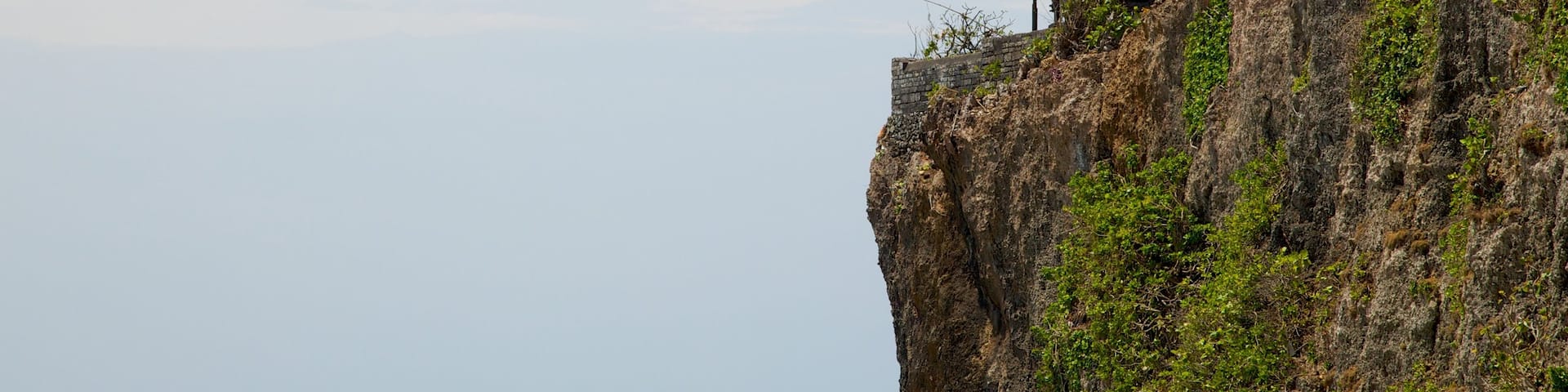 Uluwat Temple featuring a temple or place of worship and rugged coastline