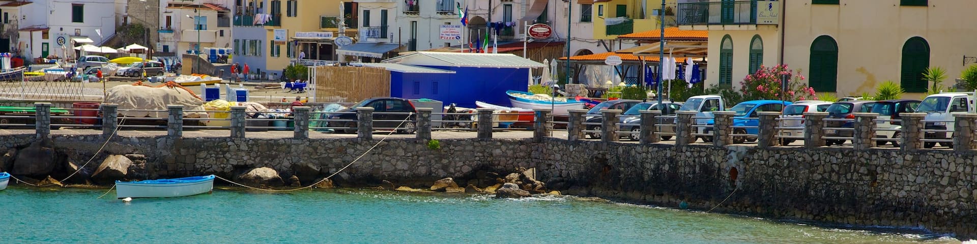 Marina di Puolo showing a coastal town and a sandy beach as well as a couple