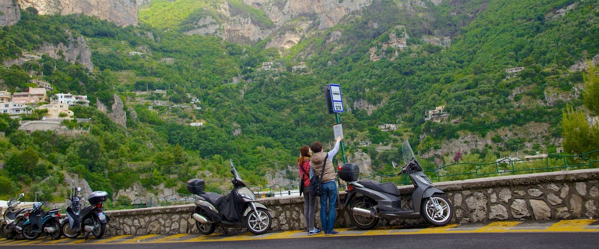 Positano welches beinhaltet Mopedfahren und Berge sowie Paar