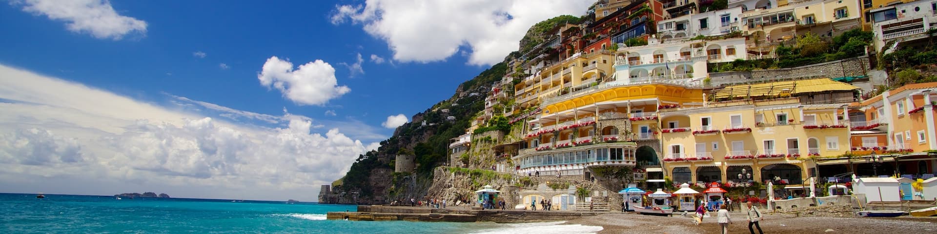 Positano which includes a coastal town and a sandy beach