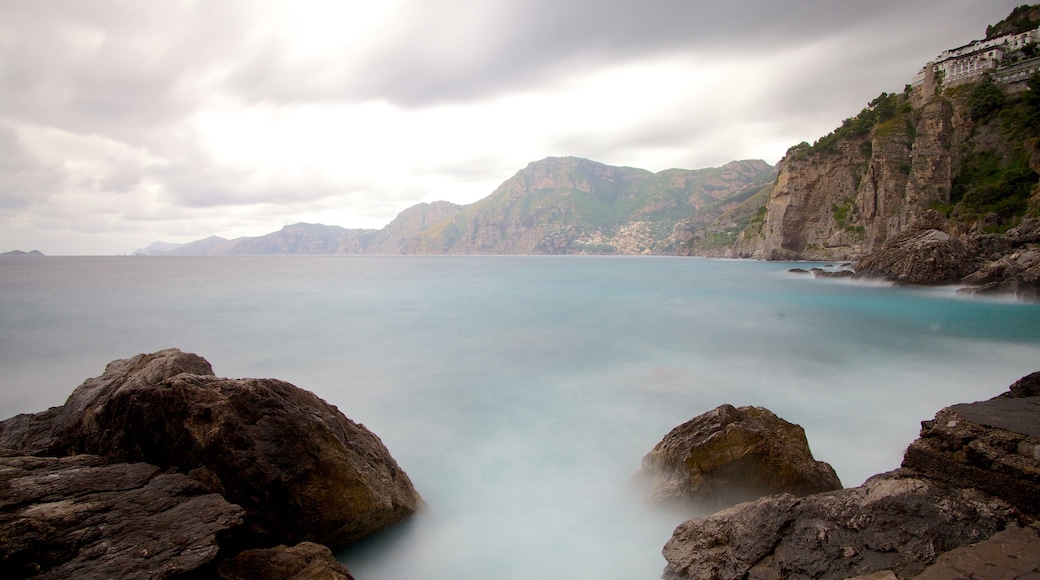 Praiano featuring rocky coastline and mist or fog