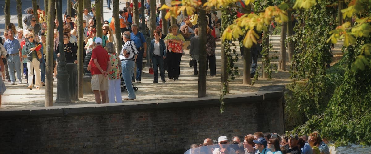 Bruges showing boating and a river or creek as well as a large group of people