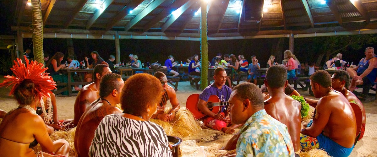 Robinson Crusoe Island which includes a beach bar, outdoor eating and night scenes