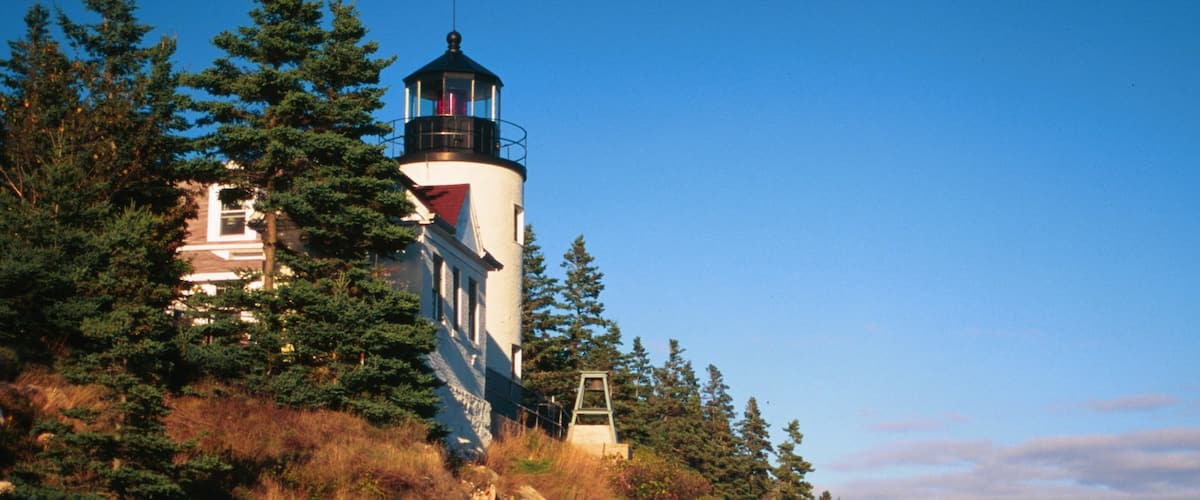 Bar Harbor showing a lighthouse and rocky coastline