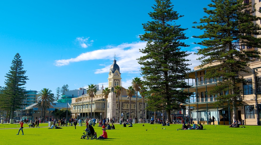 Glenelg Beach which includes a park and a city as well as a large group of people