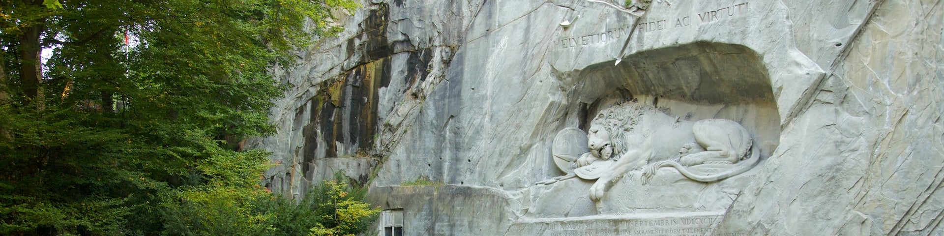 Lion Monument which includes a pond and a monument as well as a large group of people