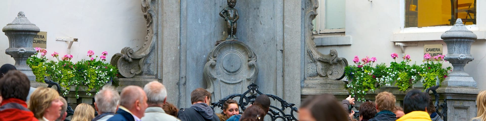 Manneken Pis Statue which includes a monument and a statue or sculpture as well as a large group of people