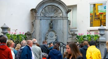 Manneken Pis mostrando un monumento y una estatua o escultura y también un gran grupo de personas