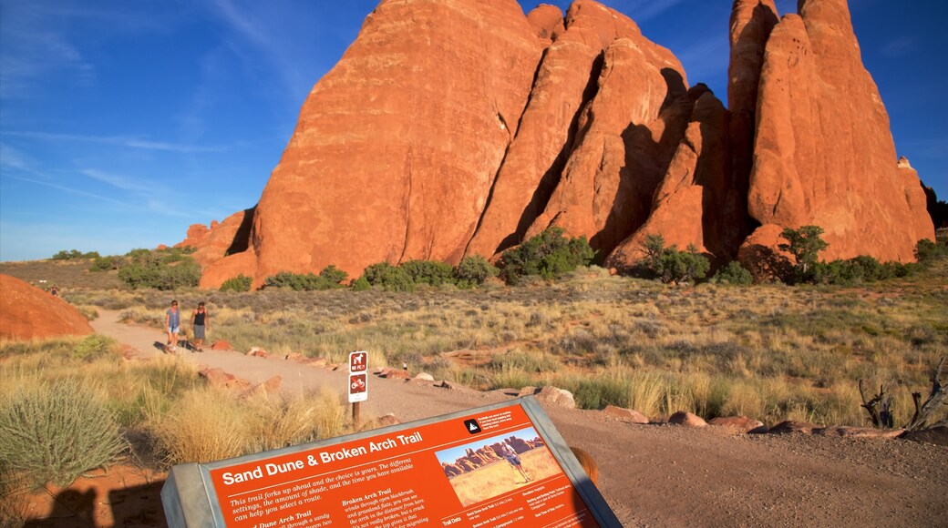 Sand Dune Arch which includes signage, a gorge or canyon and desert views