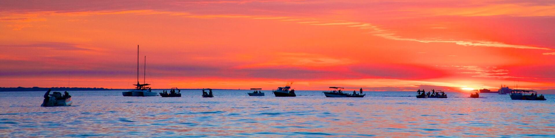 Mindil Beach which includes general coastal views, a sunset and landscape views